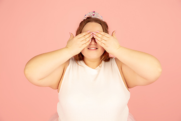 Image showing Beautiful caucasian plus size model isolated on pink studio background. Concept of inclusion, human emotions, facial expression