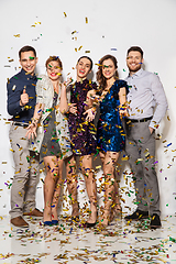 Image showing happy friends at party under confetti over white