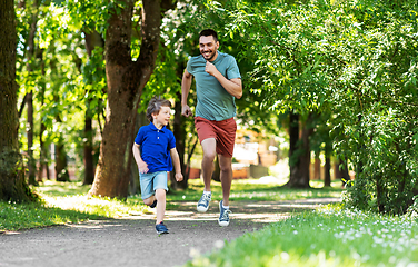 Image showing happy father and son compete in running at park