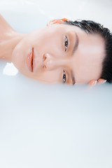 Image showing Close up female model in the milk bath with soft white glowing. Copyspace for advertising. Beauty, fashion, style, bodycare concept.