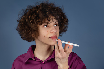 Image showing Caucasian young man\'s portrait isolated on blue studio background with copyspace