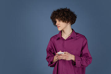 Image showing Caucasian young man\'s portrait isolated on blue studio background with copyspace