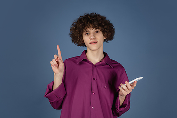 Image showing Caucasian young man\'s portrait isolated on blue studio background with copyspace