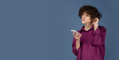 Image showing Caucasian young man\'s portrait isolated on blue studio background with copyspace