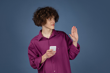 Image showing Caucasian young man\'s portrait isolated on blue studio background with copyspace