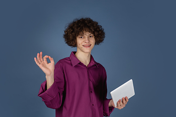 Image showing Caucasian young man\'s portrait isolated on blue studio background with copyspace