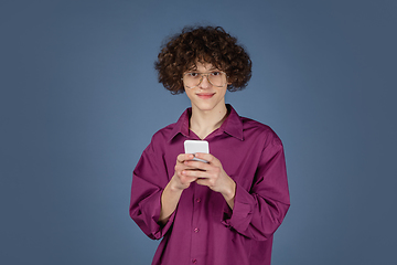 Image showing Caucasian young man\'s portrait isolated on blue studio background with copyspace