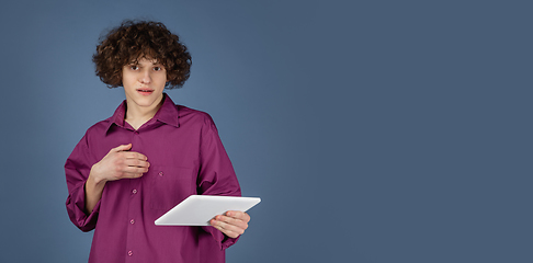 Image showing Caucasian young man\'s portrait isolated on blue studio background with copyspace