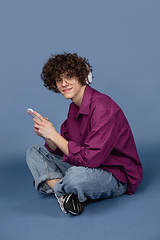 Image showing Caucasian young man\'s portrait isolated on blue studio background with copyspace