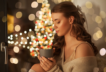 Image showing woman with coffee at window on christmas
