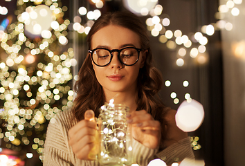 Image showing woman with christmas garland lights in glass mug