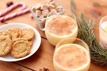 Image showing glasses of eggnog, oatmeal cookies and fir branch