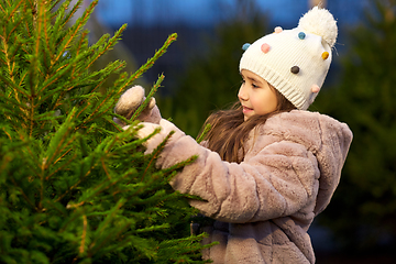 Image showing little girl choosing christmas tree at market