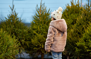 Image showing little girl choosing christmas tree at market