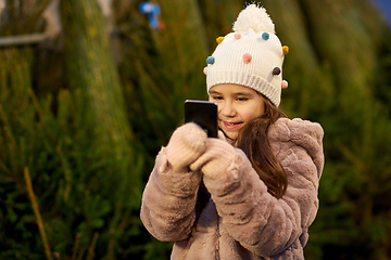 Image showing girl with smartphone at christmas tree market