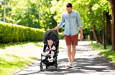 Image showing happy father with child in stroller at summer park