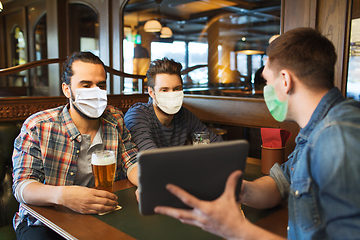 Image showing men in masks with tablet pc drink beer at bar