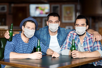 Image showing male friends in masks drinking beer at bar or pub