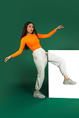 Image showing Female model in sporty outfit on bicolored background with mirror. Style and beauty concept. Close up.