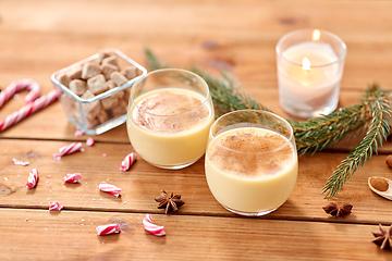 Image showing glasses of eggnog, ingredients and spices on wood