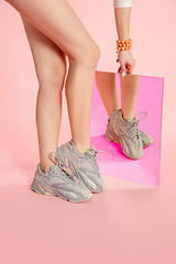 Image showing Female fit legs in fashionable shoes on coral pink background with mirror. Style and beauty concept. Close up.