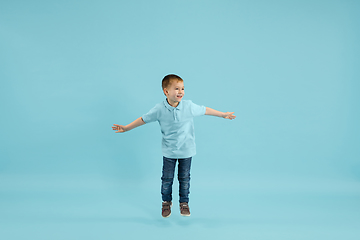 Image showing Childhood and dream about big and famous future. Pretty little boy isolated on blue background