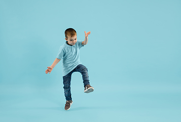 Image showing Childhood and dream about big and famous future. Pretty little boy isolated on blue background