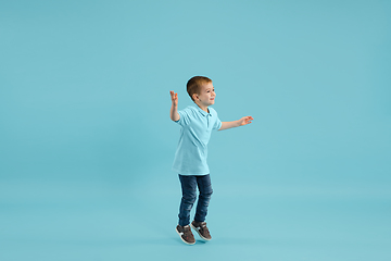 Image showing Childhood and dream about big and famous future. Pretty little boy isolated on blue background