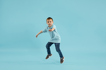 Image showing Childhood and dream about big and famous future. Pretty little boy isolated on blue background