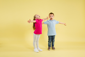 Image showing Childhood and dream about big and famous future. Pretty little kids isolated on yellow studio background