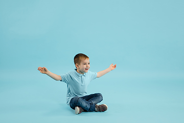 Image showing Childhood and dream about big and famous future. Pretty little boy isolated on blue background