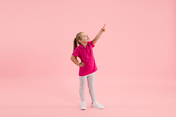 Image showing Childhood and dream about big and famous future. Pretty little girl isolated on coral pink background