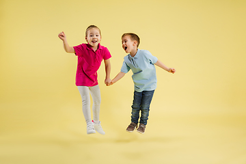 Image showing Childhood and dream about big and famous future. Pretty little kids isolated on yellow studio background