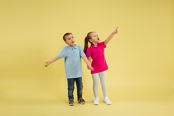 Image showing Childhood and dream about big and famous future. Pretty little kids isolated on yellow studio background