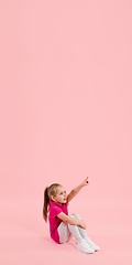 Image showing Childhood and dream about big and famous future. Pretty little girl isolated on coral pink background