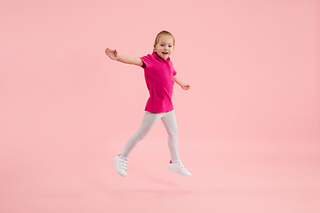 Image showing Childhood and dream about big and famous future. Pretty little girl isolated on coral pink background