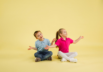 Image showing Childhood and dream about big and famous future. Pretty little kids isolated on yellow studio background