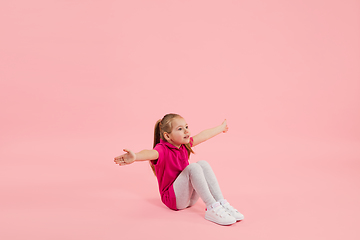 Image showing Childhood and dream about big and famous future. Pretty little girl isolated on coral pink background