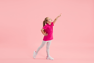 Image showing Childhood and dream about big and famous future. Pretty little girl isolated on coral pink background