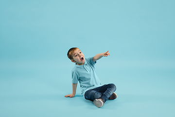 Image showing Childhood and dream about big and famous future. Pretty little boy isolated on blue background