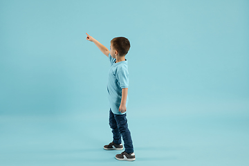 Image showing Childhood and dream about big and famous future. Pretty little boy isolated on blue background