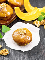 Image showing Cupcake pumpkin with orange glaze and walnuts on black board