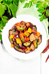 Image showing Eggplant with plums in plate on light board top