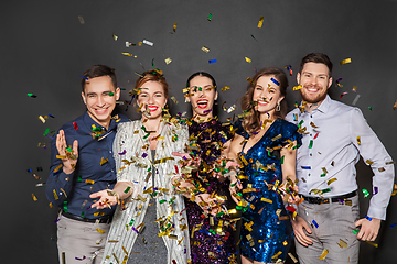 Image showing happy friends at party under confetti over black