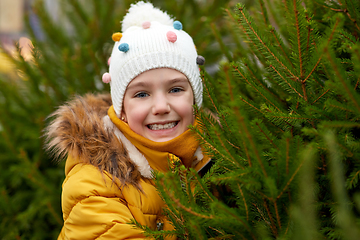 Image showing little girl choosing christmas tree at market