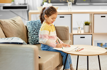 Image showing little girl drawing with coloring pencils at home