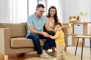 Image showing happy family with child sitting on sofa at home