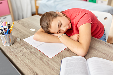 Image showing tired student girl sleeping on table at home