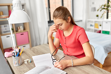 Image showing tired teenage student girl with glasses at home