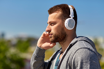 Image showing man in headphones listening to music outdoors